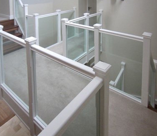 Landing with a glass balustrade with a white handrail 